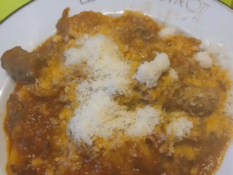 深盘里的自制帕尔马火腿意式饺子，淋着番茄辣香肠酱，撒满帕玛森奶酪碎